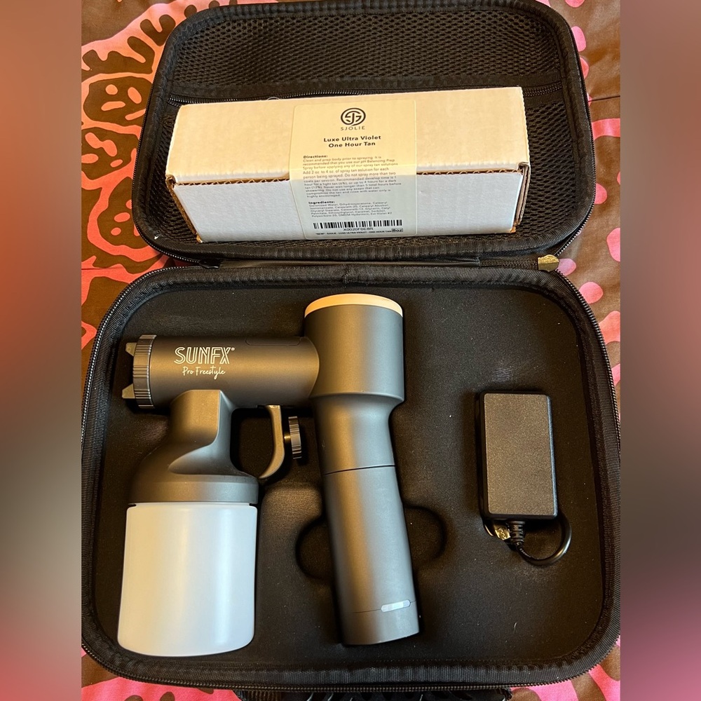 Spray tan gun and bottle of solution